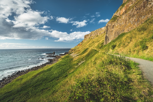 Inclinação verde íngreme com caminho turístico. Irlanda.