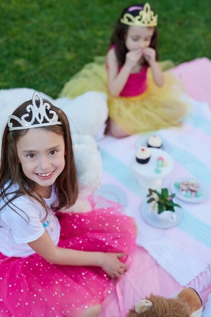 Incluso las princesas disfrutan de los picnics Retrato de una niña haciendo un picnic con su hermana afuera