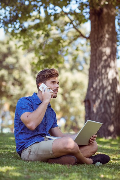 inconformista que usa la computadora portátil en el parque