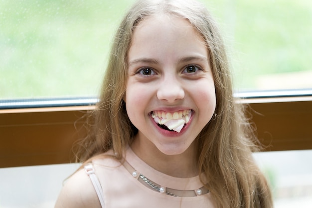 Incorregible goloso. Niño hambriento. Chica tiene dulces malvaviscos en la mano. Desafío de malvavisco. Postre dulce marshmallo Challenge aceptado w. Niña niño come dulces y golosinas. Calorías y dieta.