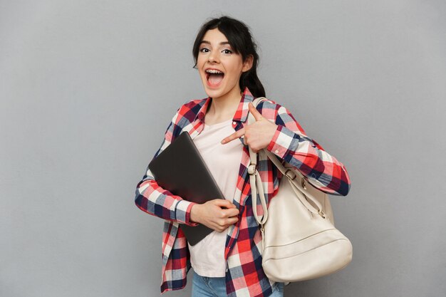 Increíble jovencita emocional que muestra la computadora portátil.