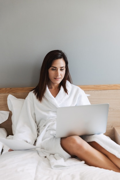 increíble mujer de negocios joven y bella en el interior de su casa usando la computadora portátil.