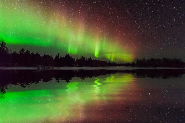 Increíble paisaje invernal con auroras boreales y estrellas