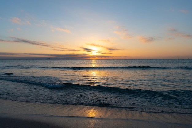 Increíble paisaje marino con cielo nublado sobre el agua del amanecer del mar o el océano con barcos en el horizonte, el atardecer o el amanecer.