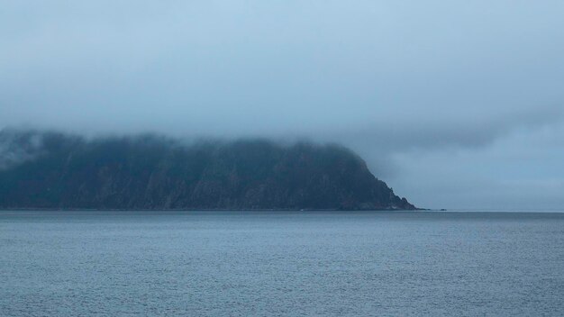 Increíble paisaje marino de rocas con nubes bajas corte mar azul con rocas oscuras de la costa en clima nublado