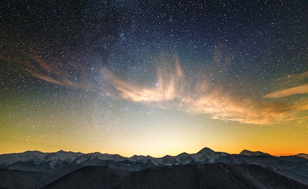 Increíble paisaje de montaña nocturna con picos altos.