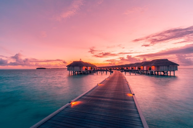 Increíble panorama de puesta de sol en Maldivas. Resort de lujo villas marinas con luces led suaves cielo colorido
