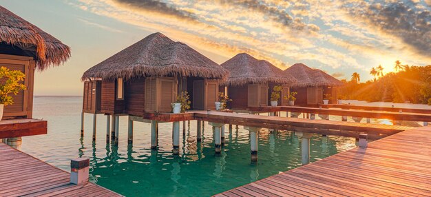 Increíble panorama de puesta de sol en Maldivas. Villas de lujo, nubes de cielo coloridas. Vacaciones en pareja