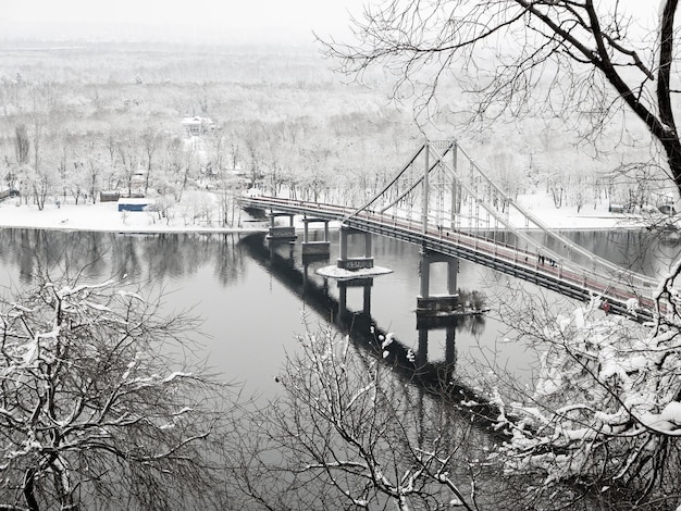 Increíble parque de la ciudad de invierno de cuento de hadas cubierto de nieve Fondo de temporada de Navidad Vista al puente peatonal en Kiev Ucrania