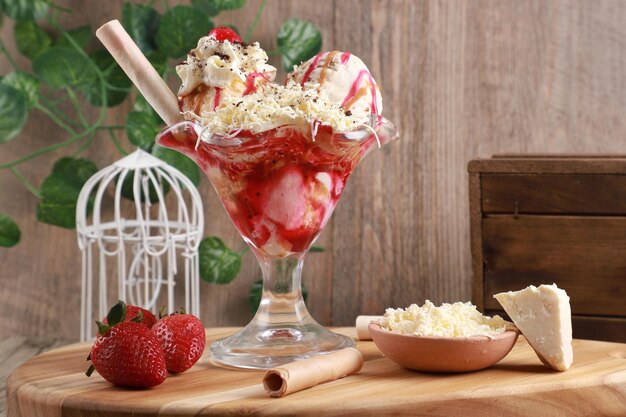 increíble preparación de helado con bayas rojas, cereza, fresa y fondo de madera