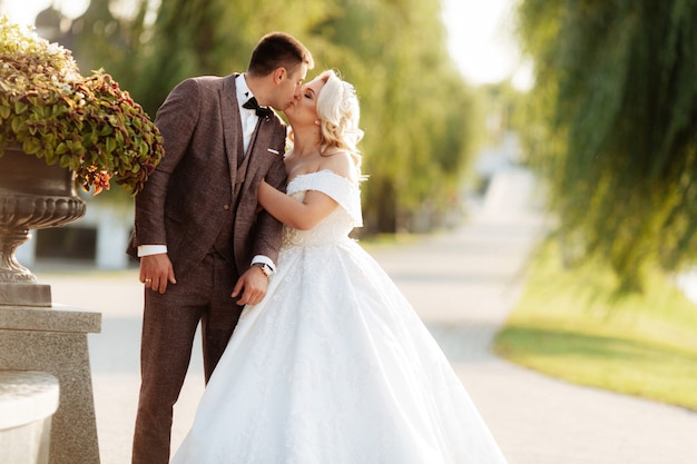 Increíble sonriente pareja de novios. Bonita novia y novio elegante.