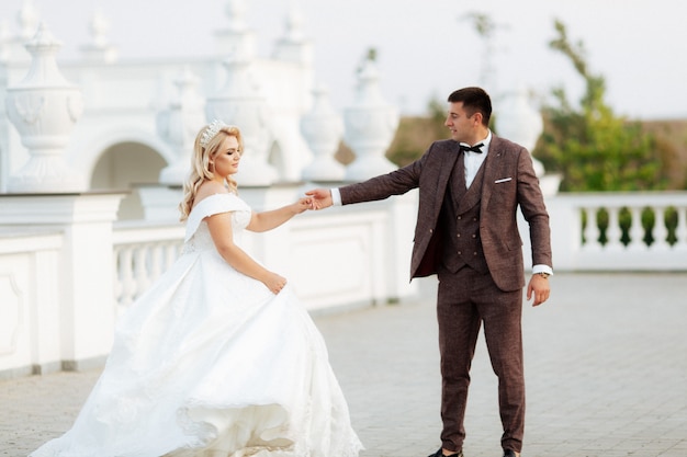 Increíble sonriente pareja de novios. Bonita novia y novio elegante.