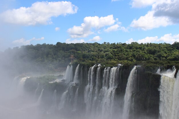 Increíble vista de una cascada con niebla en un parque de Brasil rodeado de árboles.