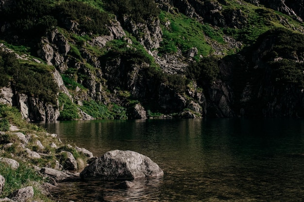 Increíbles montañas rocosas con nubes y lago en verano para viajar