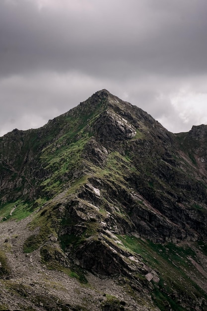 Incríveis montanhas rochosas com nuvens e lago no verão para viagens.