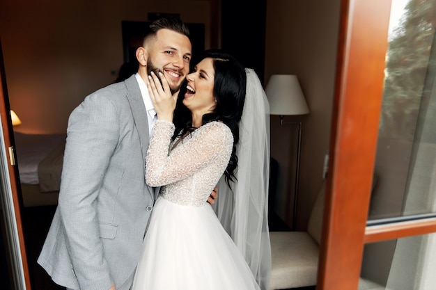 Incrível casal sorridente de casamento. Linda noiva e noivo elegante.