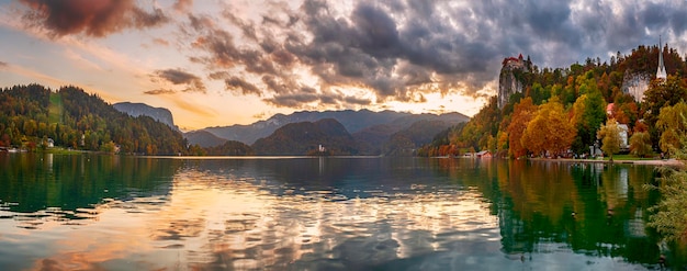 Incrível panorama de outono do pôr do sol Castelo de Bled construído no topo de um penhasco com vista para o lago Bled, localizado em Bled, Eslovênia.