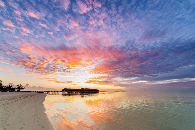 Incrível pôr do sol panorâmico Maldivas. Seascape de villas resort de luxo, reflexo de água do horizonte do mar