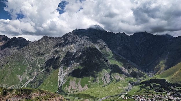 Incrível vista das montanhas verdes sob a sombra das nuvens