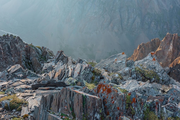 Incrível vista para a montanha do penhasco em altitude muito alta Paisagem alpina cênica com borda do precipício com pedras afiadas contra grande parede de montanha Belas paisagens na borda do abismo com pedras afiadas