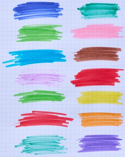 Incubação com canetas de ponta de feltro multicoloridas em uma folha de papel xadrez