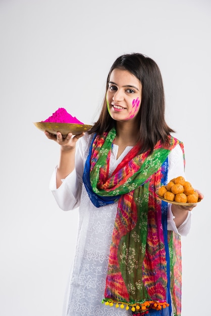 Inder feiern Holi mit süßem Laddu, Farben in Thali und Farbspritzer