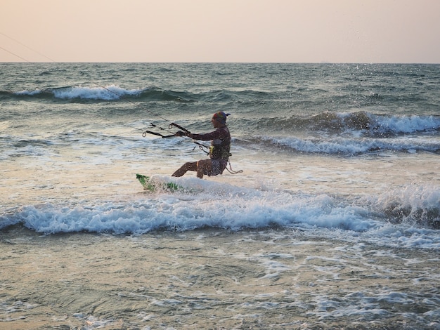 India, Goa, Arambol, un hombre de kitesurf cerca de la costa al atardecer