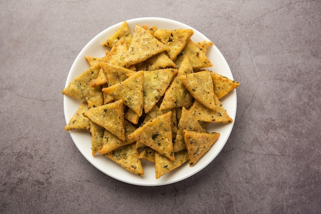 India Namkeen palak o Methi Mathri Forma de triángulo o Tikona - Fenogreco salado o hojas de espinaca mezcladas Galletas