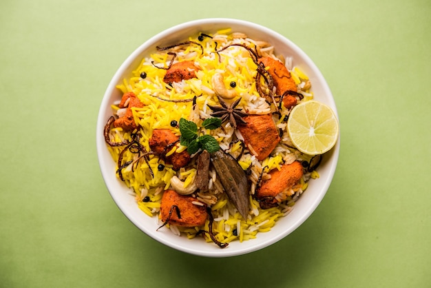 Indian Chicken Tikka Biriyani servido en un bol con yogur. enfoque selectivo