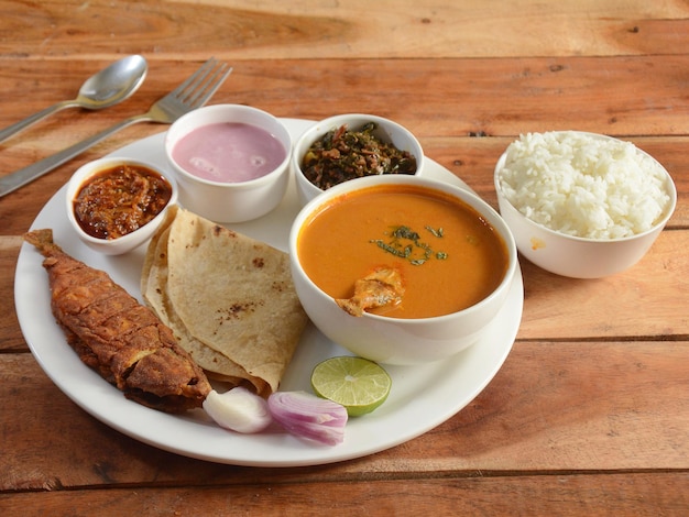 Indian Fish thali de una cocina india consiste en pescado frito, curry, arroz al vapor, roti y encurtidos, enfoque selectivo