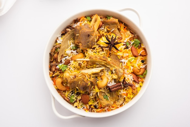 Indian Mutton Biryani preparado em arroz Basmati servido com molho de iogurte sobre fundo sombrio, Foco seletivo