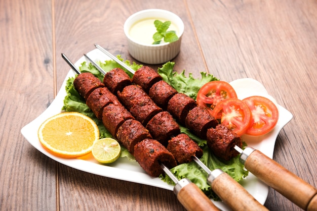 Indian Mutton Seekh Kabab servido com salada verde, foco seletivo