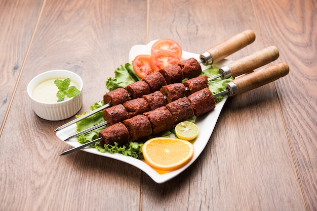 Indian Mutton Seekh Kabab servido con ensalada verde, enfoque selectivo