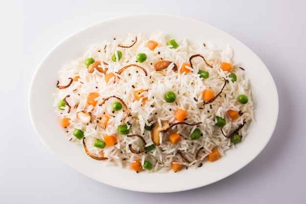 Indian Pulav o veg biryani elaborado con arroz basmati servido en un plato de cerámica blanca, enfoque selectivo