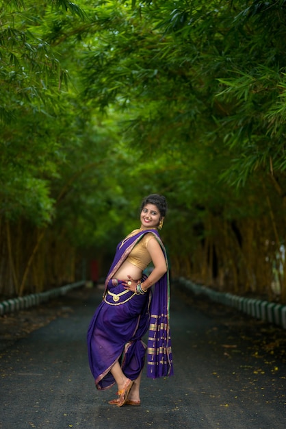 Indiana tradicional linda jovem em sari posando ao ar livre