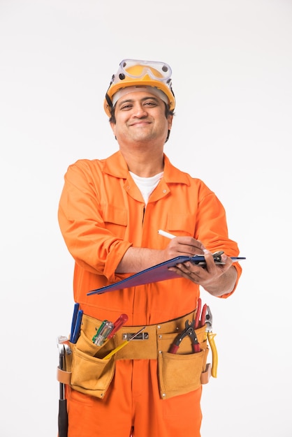 Indiano asiático bonito eletricista ou engenheiro em ação com o chapéu de segurança amarelo isolado