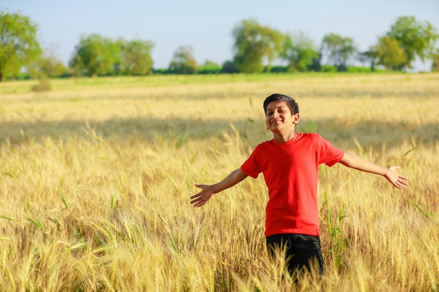 Indiano / asiático garoto jogando no campo de trigo