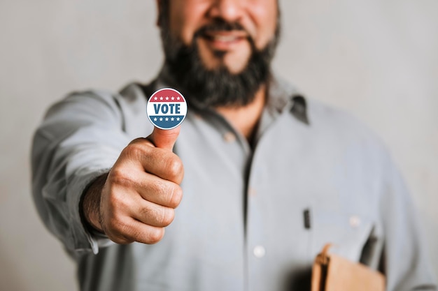 Indiano barbudo mostrando um adesivo de voto