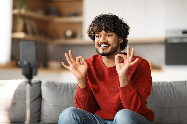 Indiano gravando vídeo em casa com smartphone no tripé