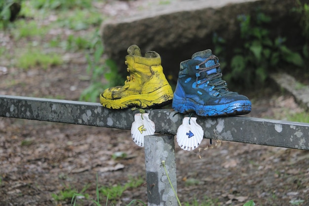 Foto indicador de direção fátima saint james way botas de trekking e bastões encostados na parede de pedra