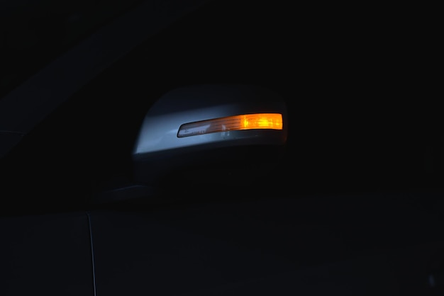 Foto indicador iluminado en el espejo lateral del automóvil por la noche