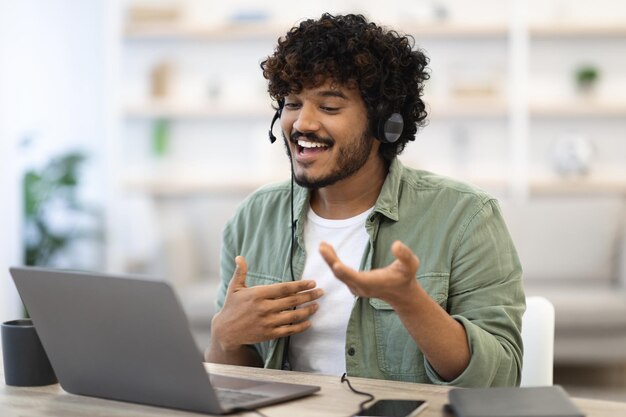 Indígena bonito alegre trabalhando online tendo videoconferência