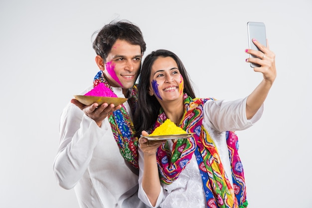 Los indios celebran holi con dulce laddu, colores en thali y salpicaduras de color