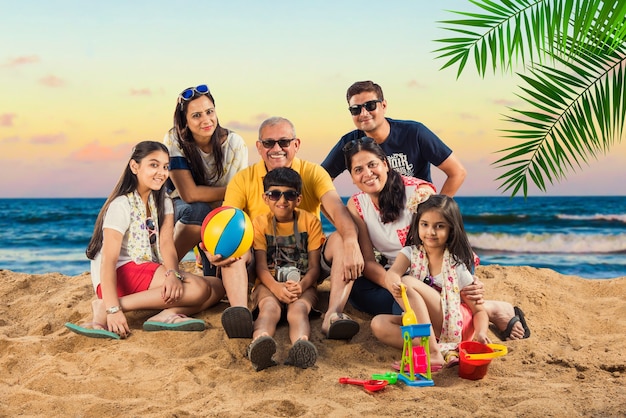 Indische asiatische Familie, die im Sommer am Strand genießt