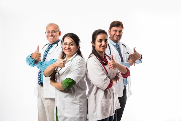 Indische asiatische Ärzte Gruppenfoto mit Erfolg oder Daumen hoch Zeichen. stehend auf weißem Hintergrund isoliert. selektiver Fokus