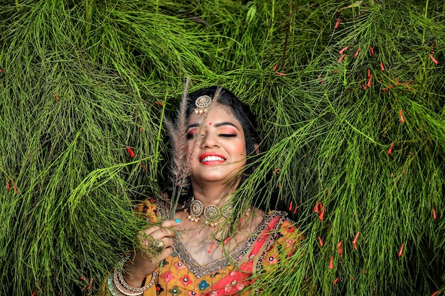 indische braut, die traditionelles lengha und schmuck mit schönem gesicht trägt