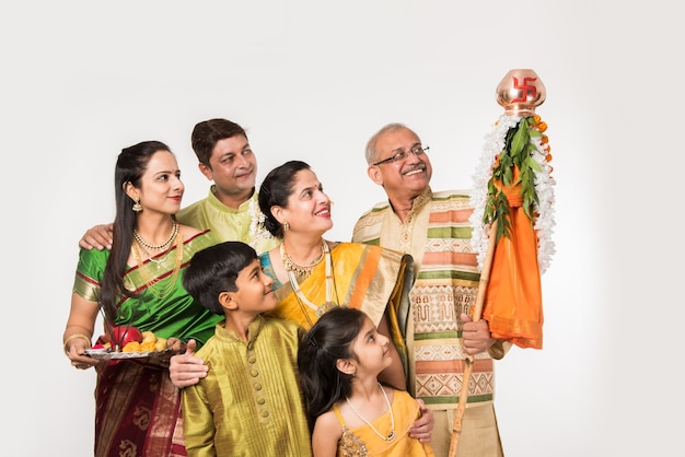 Indische Familie feiert Gudi Padwa oder Ugadi Festival, während Dame oder Frau Puja oder Pooja Thali hält, es ist ein neues Jahr in der hinduistischen Religion