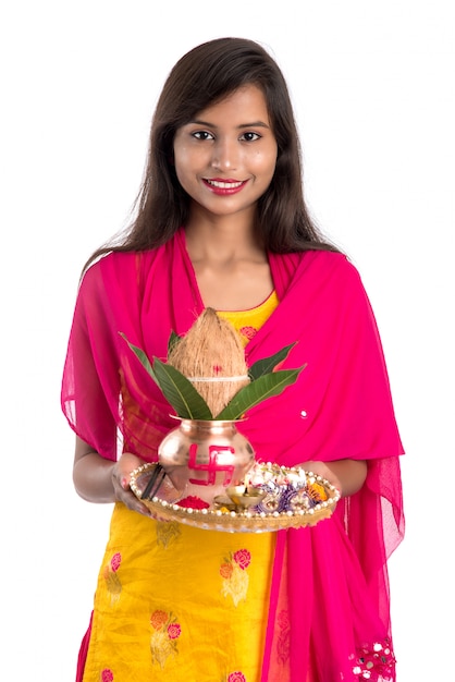 Indische Frau hält eine traditionelle Kupfer-Kalash mit Pooja Thali, Indian Festival, Kupfer-Kalash mit Kokosnuss- und Mangoblatt mit Blumendekor, essentiell in Hindu Pooja.