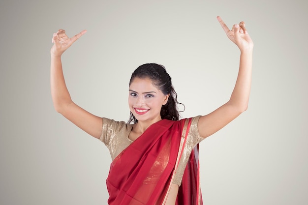 Indische Frau in Saree-Kleidung tanzt im Studio