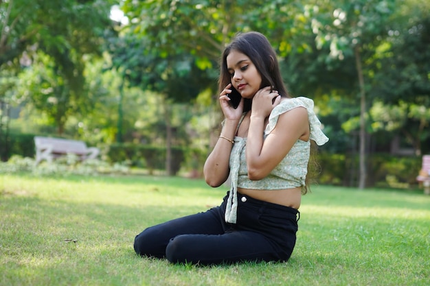 Indische Frau spricht im Freien mit jemandem am Telefon